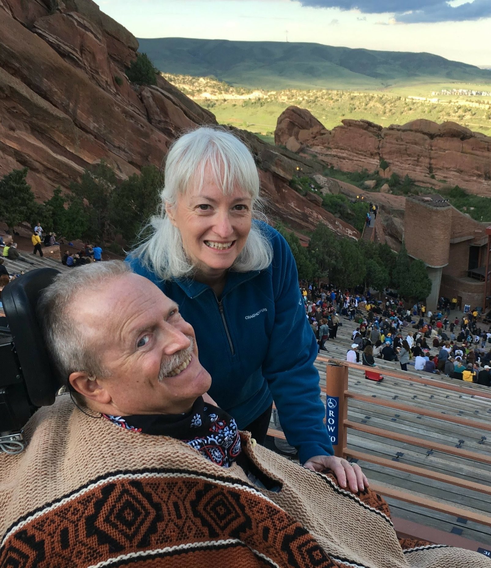 A photograph of Robin and Bruce Goguen. They are seated outside and smiling up towards the camera.