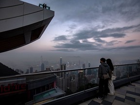 Visitors at Victoria Peak at dusk in Hong Kong, China, on Thursday, Jan. 27, 2022. Hong Kong's economic performance in the fourth quarter may provide little consolation as the city struggles to bring the omicron wave under control, putting pressure on the government to dole out more stimulus for hard-hit sectors like retail. Photographer: Paul Yeung/Bloomberg