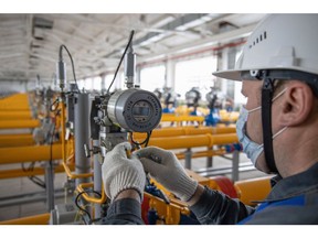 A worker installs new gas flow monitoring equipment inside a gas collect point of the Kasimovskoye underground gas storage facility, operated by Gazprom PJSC, in Kasimov, Russia, on Wednesday, Nov. 17, 2021. Russia signaled it has little appetite for increasing the natural gas it transits through other territories to Europe as the winter heating season gets underway. Photographer: Andrey Rudakov/Bloomberg